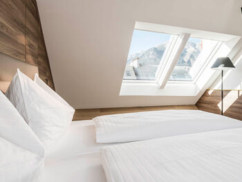 Ein großes Fenster stellt ein lichtdurchflutetes Schlafzimmer mit einem Doppelbett im Panorama Apartment 2 sicher